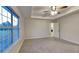 Bright bedroom with tray ceilings, ceiling fan, and a large window with backyard view at 943 Colvin Dr, Locust Grove, GA 30248