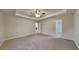 Large main bedroom with a tray ceiling, carpet, and an ensuite bathroom at 943 Colvin Dr, Locust Grove, GA 30248