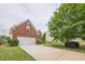 Two-story brick home with a two-car garage, manicured lawn, and mature landscaping at 1130 Laurel Cove Dr, Snellville, GA 30078