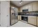 Well-lit kitchen features stainless steel appliances, tile backsplash, and off-white cabinets at 1130 Laurel Cove Dr, Snellville, GA 30078