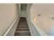 Carpeted staircase with white handrails leads to the upper level of the home at 18 Loth Wages (Lot 18) Rd, Dacula, GA 30019