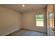 This bedroom features neutral carpet and walls, one window and a door at 2 Loth Wages (Lot 2) Rd, Dacula, GA 30019