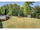 Lush green backyard featuring a storage shed surrounded by mature trees, offering privacy and space at 345 Piedmont Cir, Covington, GA 30016