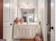 Bright bathroom features white vanity, mirror, and decorative urns flanking either side of the sink at 345 Piedmont Cir, Covington, GA 30016