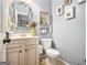 Charming half bathroom boasts a decorative mirror, fresh paint, and updated fixtures at 345 Piedmont Cir, Covington, GA 30016