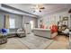 Spacious main bedroom featuring tray ceilings, carpeted floor, a sitting area, and modern furnishings at 345 Piedmont Cir, Covington, GA 30016