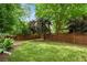 This is a large fenced in back yard with grass, plants, and trees at 901 United Se Ave, Atlanta, GA 30316