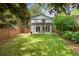 Spacious backyard with lush green grass, mature trees, and a stylish pergola over a patio at 901 United Se Ave, Atlanta, GA 30316