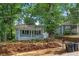 View of a single-story light gray home nestled among mature trees in a residential neighborhood at 1939 Dunlap Ave, Atlanta, GA 30344