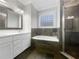 Elegant bathroom with a luxurious soaking tub, modern fixtures, a glass enclosed shower, and refined tile work at 2419 Boulder Se Rd, Atlanta, GA 30316