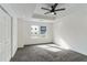Spacious main bedroom featuring a tray ceiling, ceiling fan, carpet flooring and two windows at 4011 Redan Rd # 7, Stone Mountain, GA 30083