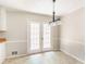 Bright dining area featuring double doors, wainscoting, and a modern light fixture at 263 Austin Rd, Stockbridge, GA 30281