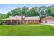 Inviting single-story brick home with mature trees, an attached garage, and a covered front porch at 263 Austin Rd, Stockbridge, GA 30281