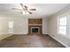 Bright living room features a brick fireplace, ceiling fan, and a view of the backyard at 263 Austin Rd, Stockbridge, GA 30281
