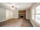 Bright living room features a brick fireplace, ceiling fan, and a view of the backyard at 263 Austin Rd, Stockbridge, GA 30281