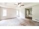 Bright main bedroom boasts a tray ceiling, fan, carpet, and ensuite bathroom access at 263 Austin Rd, Stockbridge, GA 30281