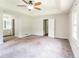 Main bedroom with a tray ceiling, ceiling fan, and access to an ensuite bathroom and closet at 263 Austin Rd, Stockbridge, GA 30281