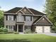 Charming two-story home featuring a mix of stone and siding, complemented by a well-manicured lawn and a two car garage at 3272 Lions Ruby Ln, Atlanta, GA 30349