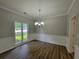 Dining room with modern chandelier, chair rail detail, and wood-look flooring at 3838 Glenlake Springs Nw Ct, Kennesaw, GA 30144