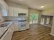 Bright kitchen featuring white cabinets, granite counters, and an open view to the living area at 3838 Glenlake Springs Nw Ct, Kennesaw, GA 30144