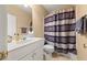 Bathroom with a white sink and cabinet, toilet and shower with a horizontally striped shower curtain at 59 Townview Dr, Alpharetta, GA 30022