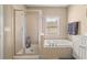 Bright bathroom with a soaking tub, a separate shower, and natural light from a window at 59 Townview Dr, Alpharetta, GA 30022