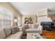 Cozy living room showcasing a fireplace, mantle, plush sofas, and natural light from a window with blinds at 59 Townview Dr, Alpharetta, GA 30022