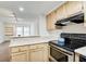 Open kitchen with wooden cabinets, countertop, and view into the living area at 199 14Th St # 409, Atlanta, GA 30309