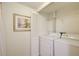 This cozy laundry area features a washer and dryer with overhead shelving and white walls at 199 14Th St # 409, Atlanta, GA 30309