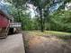 Large wooded backyard featuring a deck, concrete patio, and direct access to nature at 2184 River Acres Ct, Lithonia, GA 30058