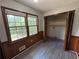 Sunlit bedroom features wood paneling, large windows, and a spacious closet for ample storage at 2184 River Acres Ct, Lithonia, GA 30058