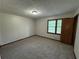 A carpeted bedroom featuring a window, and an access door at 2184 River Acres Ct, Lithonia, GA 30058