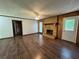 Open living room with fireplace, wood paneling, and hardwood floors, ideal for entertaining guests at 2184 River Acres Ct, Lithonia, GA 30058
