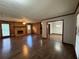 Spacious living room boasts wood paneling, a classic brick fireplace, and gleaming hardwood floors at 2184 River Acres Ct, Lithonia, GA 30058