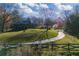 Scenic view of a cabin-style home with a green metal roof, set back from a curving driveway at 3721 Mason Creek Rd, Winston, GA 30187