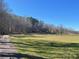 Scenic view of a green meadow and mature trees under a clear blue sky at 3721 Mason Creek Rd, Winston, GA 30187