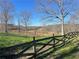 Fenced-in grassy area with mature trees under a bright blue sky at 3721 Mason Creek Rd, Winston, GA 30187