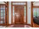Elegant foyer with hardwood floors and a natural wood door with glass sidelights at 3220 Millwood Se Trl, Smyrna, GA 30080