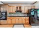 Kitchen features light wood cabinets, black appliances, a black countertop, and a diamond pattern backsplash at 3220 Millwood Se Trl, Smyrna, GA 30080