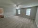 Spacious living room with neutral carpet, ceiling fan, and natural light from two large windows at 4911 Hairston Pl, Stone Mountain, GA 30088