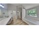 Bright bathroom features a dual sink vanity, soaking tub, and walk-in closet access at 5368 Knights Lndg, Ellenwood, GA 30294