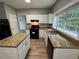 Bright kitchen with stainless appliances, granite counters, and wood flooring at 675 Stonebridge Loop, Lithonia, GA 30058