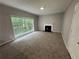 Carpeted living room with a fireplace and a large picture window at 675 Stonebridge Loop, Lithonia, GA 30058
