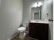 Powder room with single sink vanity, updated fixtures and a mirror at 675 Stonebridge Loop, Lithonia, GA 30058