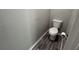 Compact powder room with a wood-look floor, toilet, and brushed nickel toilet paper holder at 675 Stonebridge Loop, Lithonia, GA 30058
