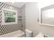 Modern bathroom features a shower-tub combination, geometric tile and large window at 823 Catherine St, Forest Park, GA 30297