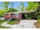 This cozy home has a large carport, landscaped front yard, black trimmed windows, and a brick facade at 823 Catherine St, Forest Park, GA 30297