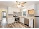 Well-lit kitchen with stainless steel appliances, white cabinetry and stylish geometric tiled backsplash at 823 Catherine St, Forest Park, GA 30297
