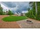 Spacious backyard with lush green lawn, patio, and firepit for outdoor entertaining at 100 Ashley Hall Ct, Woodstock, GA 30188
