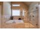 Modern bathroom with a soaking tub, glass shower, and neutral tile, offering a serene and stylish space to unwind at 100 Ashley Hall Ct, Woodstock, GA 30188